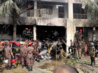 Bombeiros e soldados são vistos perto dos destroços de um avião da força aérea que caiu em uma faculdade em Dhaka, Bangladesh