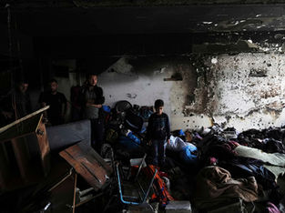 Palestinianos inspecionam um edifício da ONU depois de ter sido atingido por um ataque israelita