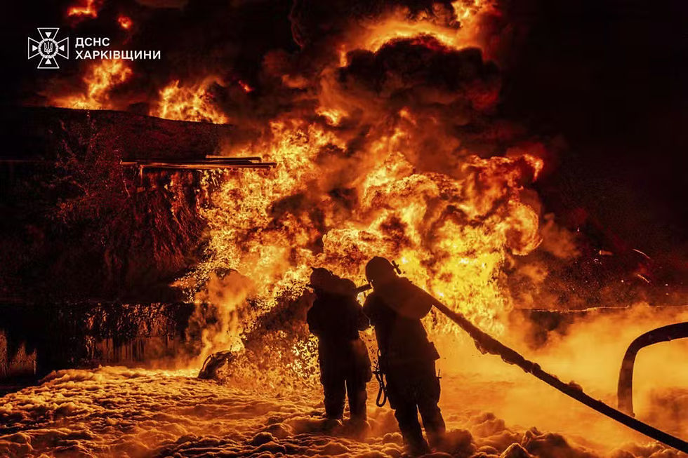 Agentes dos serviços de emergência trabalham para apagar um incêndio após um ataque russo na região de Kharkiv