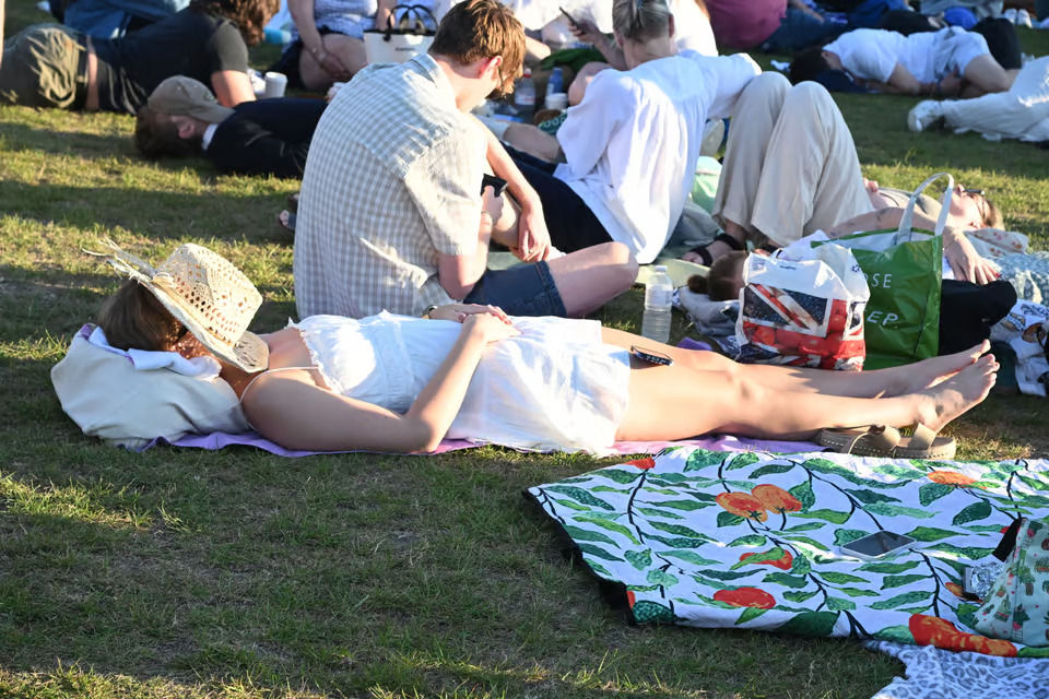 Fãs na fila para entrar em Wimbledon aproveitam o sol da manhã