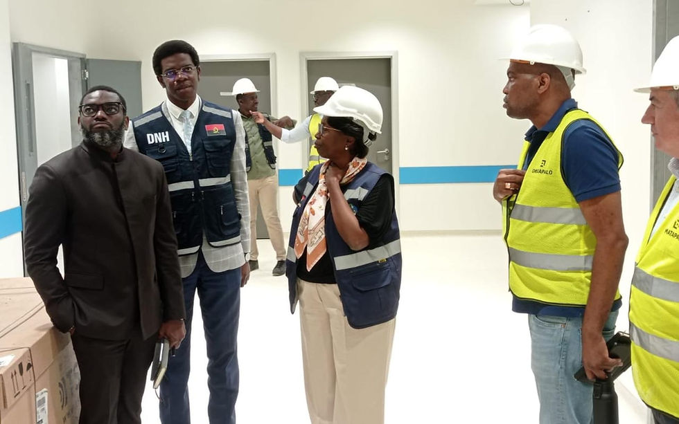 Um grupo de profissionais, alguns usando capacetes e coletes de segurança, estão reunidos em um ambiente interno que parece ser um canteiro de obras ou uma instalação recém-concluída.