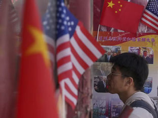 Homem aparece de perfil e bandeiras da china e dos EUA aparecem ao seu redor