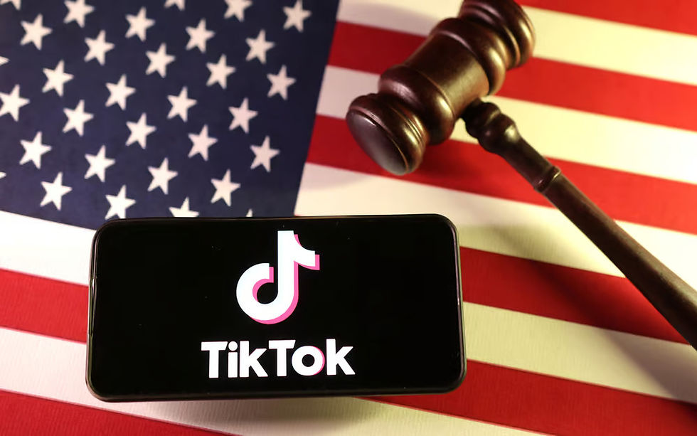 Smartphone com logo do TikTok na tela, ao fundo tem uma bandeira dos EUA com um malhete sobre ela