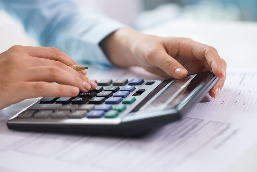 A imagem retrata uma pessoa realizando cálculos financeiros ou contábeis, utilizando uma calculadora e um lápis sobre documentos.