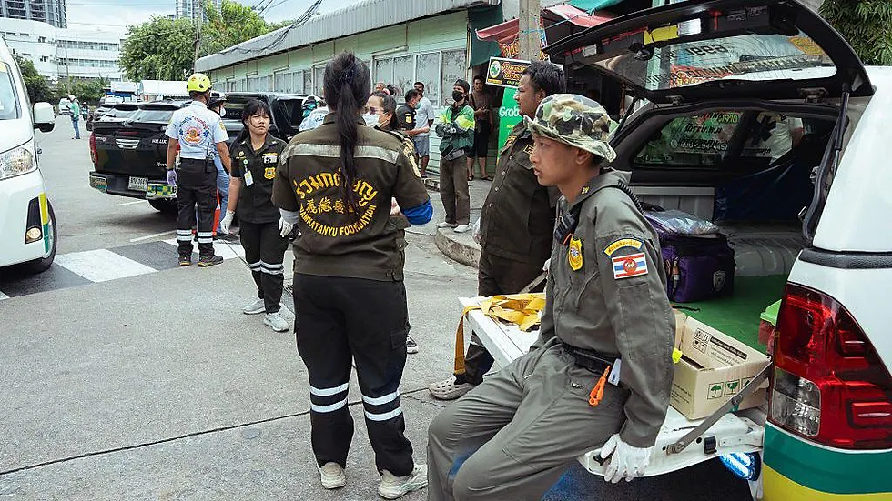 Equipe de resgate uniformizada da Fundação Ruamkatanyu atua em uma área urbana, próxima a veículos de emergência estacionados.