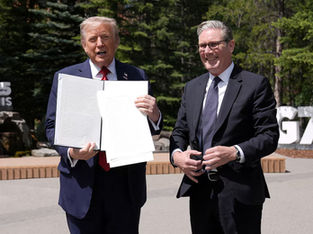 O presidente dos EUA, Donald Trump, segura um acordo comercial assinado com a Grã-Bretanha durante uma reunião com o primeiro-ministro britânico, Keir Starmer, na cúpula do G7, em Kananaskis, Alberta, Canadá.