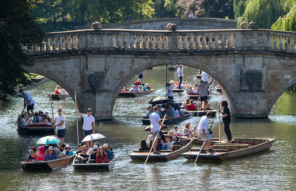 Pessoas passeiam ao longo do Rio Cam em Cambridge sob o sol