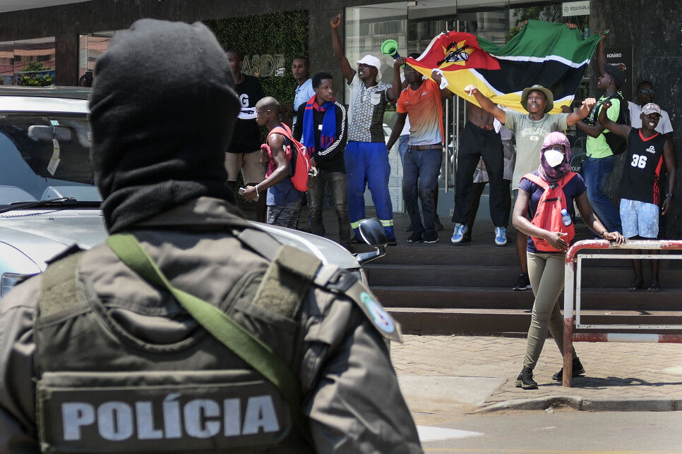 Policial aparece olhando os manifestantes à sua frente