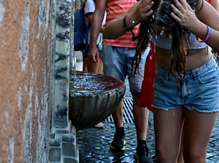 Uma menina se refresca em uma fonte em um dia quente de verão em Roma, perto do Vaticano.