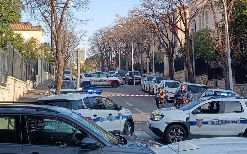 Carros da polícia estão estacionados atravessados na rua bloqueada pra investigação
