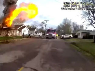 Imagem capturada de vídeo de câmera de policial, com casa explodindo ao fundo