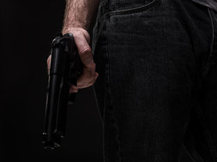 Homem segura arma de fogo em mão