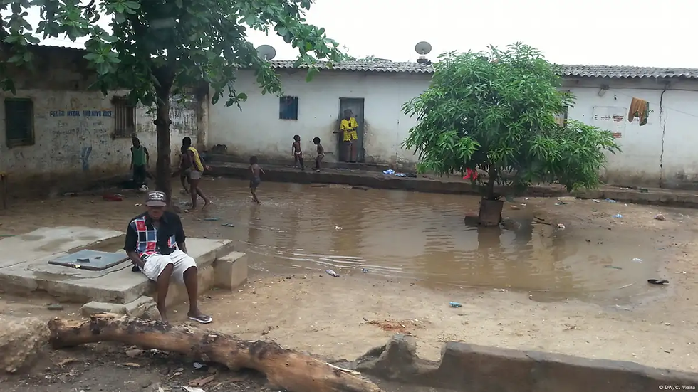 Pessoas em frente a uma casa com uma poça de água em volta