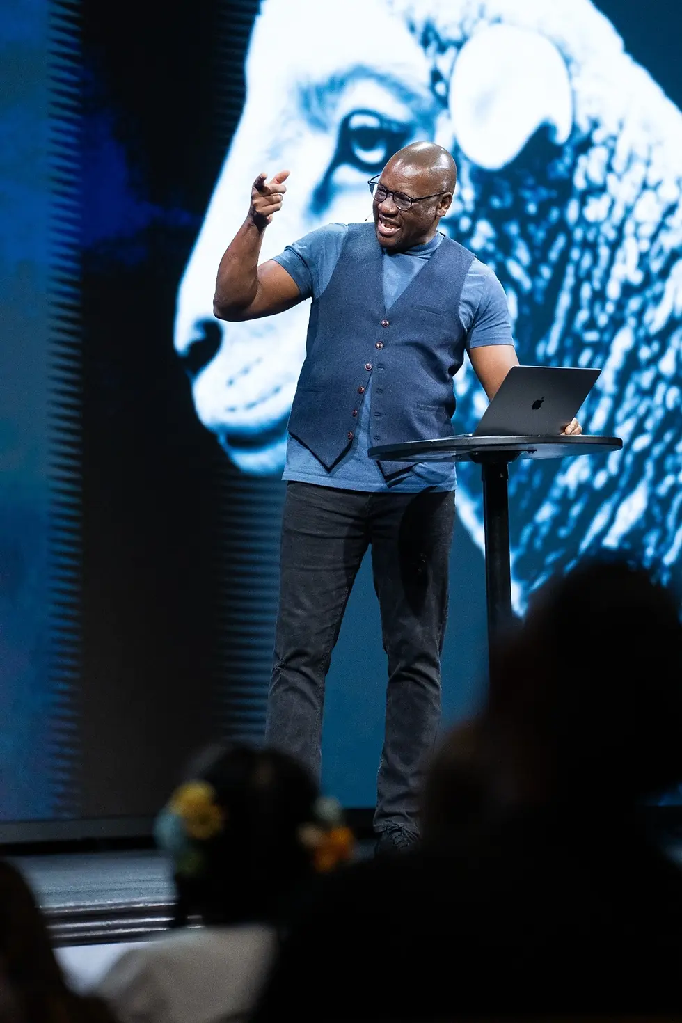 Evan Mawarire speaking energetically on stage with his hand raised and pointing toward the audience