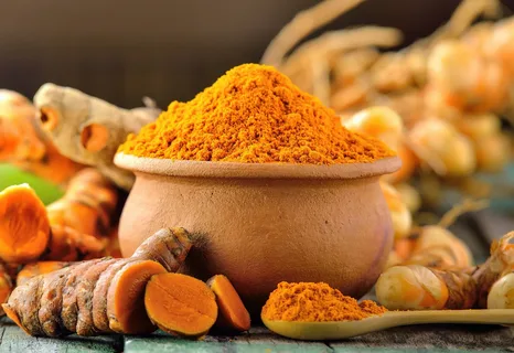 Rizoma de açafrão e pote com pó de cúrcuma