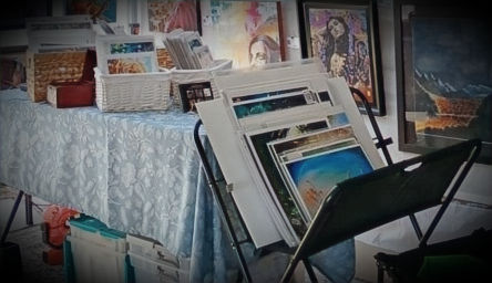 Close-up view of art prints stacked neatly in a festival display bin.
