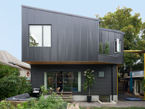 A view from the backyard shows off this house addition's interesting contrasting angles.