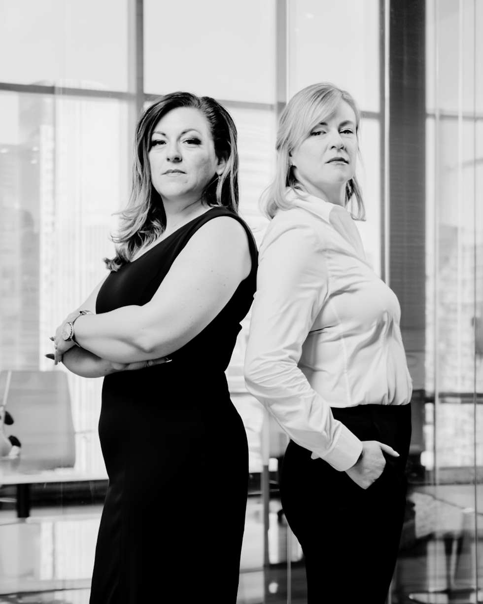 Two confident businesswomen standing back-to-back
