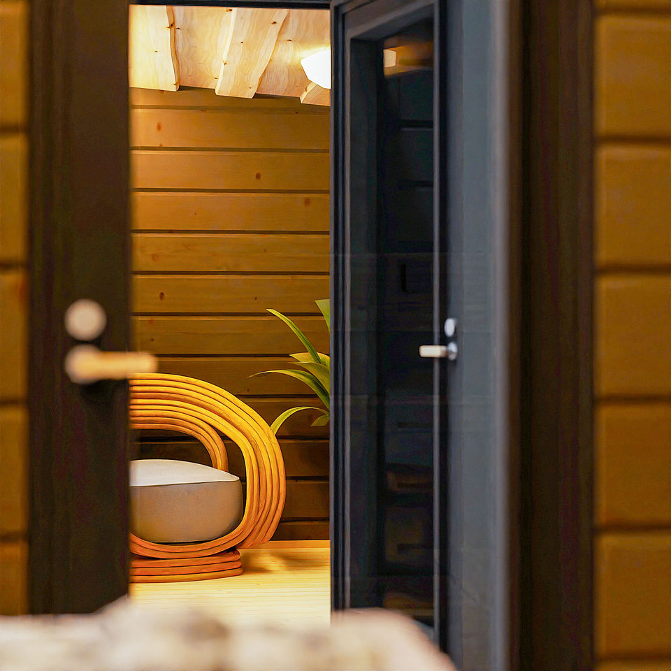 Hetki Cabin interior view from the door with armchair, cozy atmosphere and natural Finnish log walls, outdoor cabin Finland.