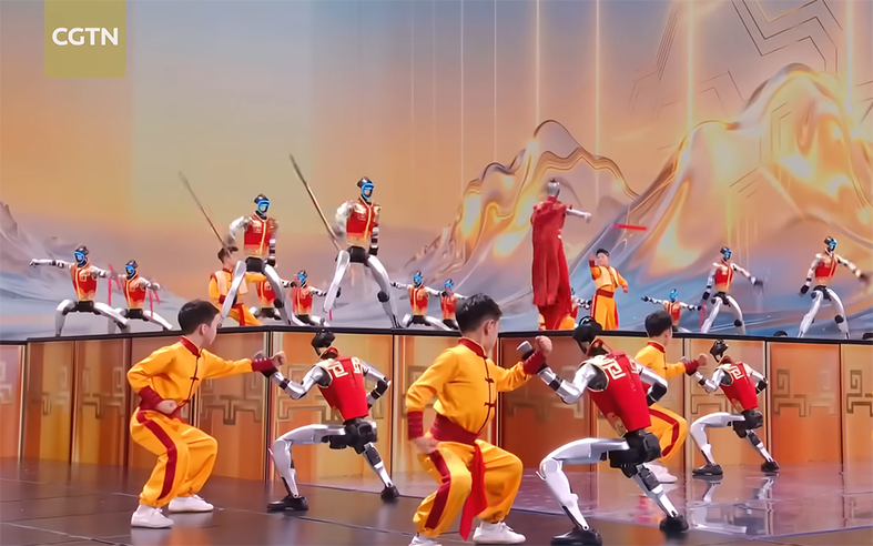 Halbwegs beruhigend: Bei den in gelb gekleideten Personen handelt es sich um normale Kinder. Ganz so weit ist der chinesische Roboter-Hersteller Unitree dann doch noch nicht. Bild: Screenshot YouTube, https://t1p.de/ya7wc