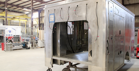Front driver side corner view of Type III ambulance for Muskogee #2658 in welding and fabrication.