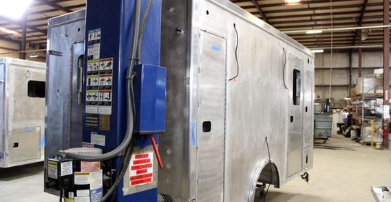 Rear curbside corner view of Harrison #2677 in welding and fabrication. Type III ambulance rear curbside corner view.