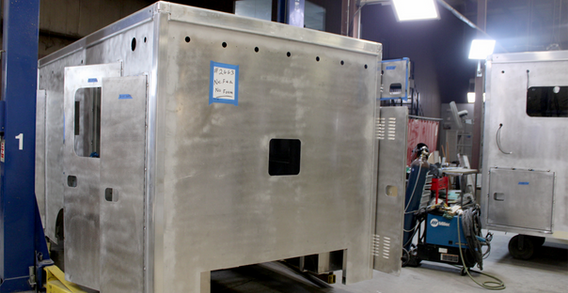 Front curbside corner view of Type I ambulance in welding and fabrication.