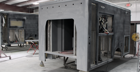 Front driver side corner view of Type III ambulance primed and being sanded for Muskogee #2654
