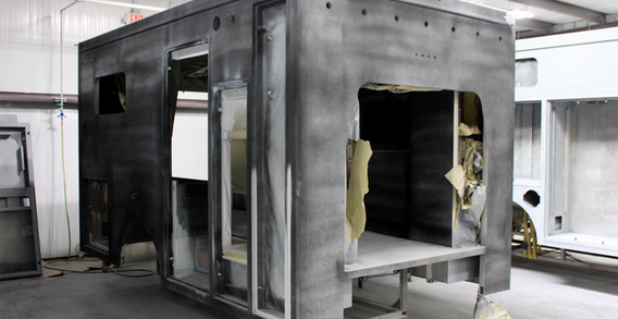 Front curbside corner view of Type III Muskogee Ambulance #2656 in paint prep and primed.