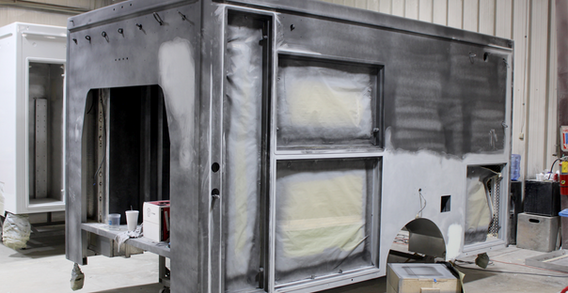 Driver side corner view of Muskogee #2653 in paint and body prep. Sanding process for Type III ambulance after being primed with paint.
