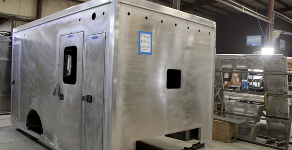 Front curbside corner view of NEFEA #2625 in welding and fabrication. Type I ambulance from Custom Truck and Body Works, Inc.