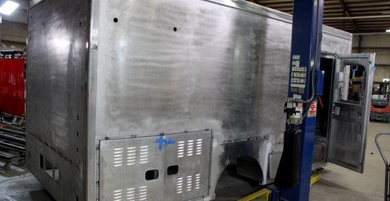 Rear curbside corner view of Ga. Comm. of Ins. #2619 on welding and fabrication lift.