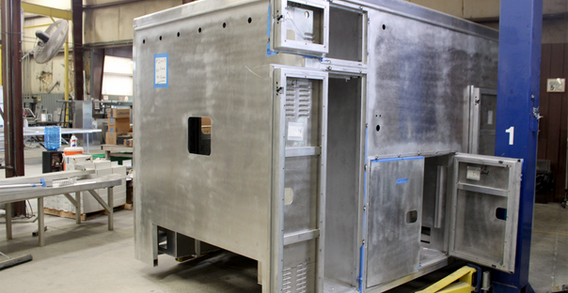 Front driver side corner view of Type I ambulance for NEFEA #2663 on welding and fabrication lift.
