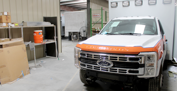 Front view of Washington Type I ambulance getting orange decal stripe.