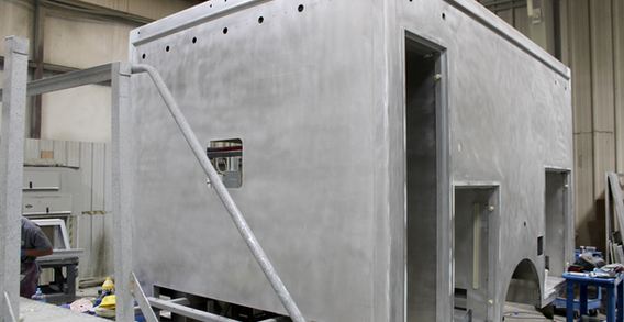 Front driver side corner view of Type I ambulance in paint and body prep for Candler #2635.