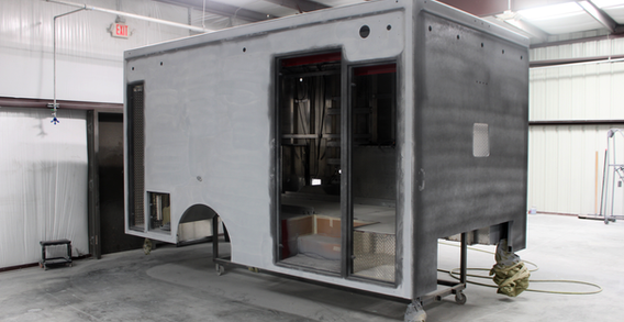 Front Curbside corner view of Type I ambulance in paint and body prep for Washington #2647. Unit has been primed.