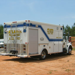 This is a white bomb squad truck with yellow lettering and a blue stripe.