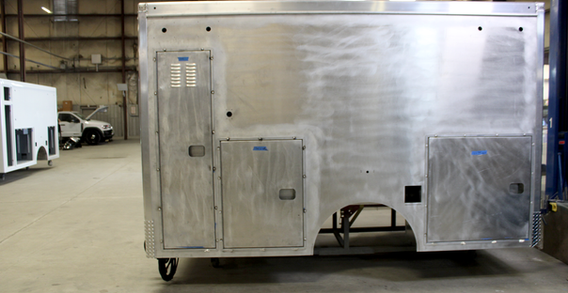 Driver side view off Type I ambulance from Custom Truck and Body Works, Inc. with compartment doors for Calhoun #2662 in welding and fabrication.