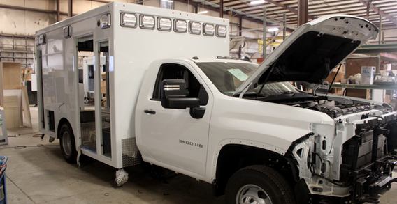 Front curbside corner view of Type I white ambulance for Calhoun #2662 in box prep.