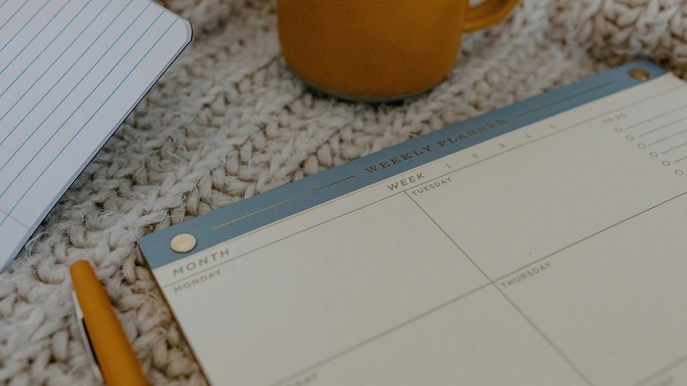 Close-up of a weekly planner and coffee mug on a textured knit blanket, symbolizing burnout, reflection, and rethinking New Year’s resolutions.
