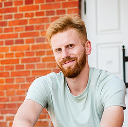 Smiling man sitting on porch of house