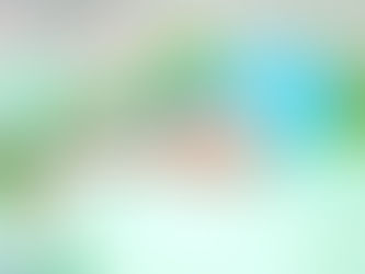 תינוק שוכב על הבטן על משטח רך בצבע פסטל, מכוסה במגבת סרוגה בצבע ירוק־טורקיז ונראה רגוע