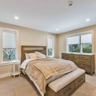 Bedroom with large bed and tv mounted on the wall
