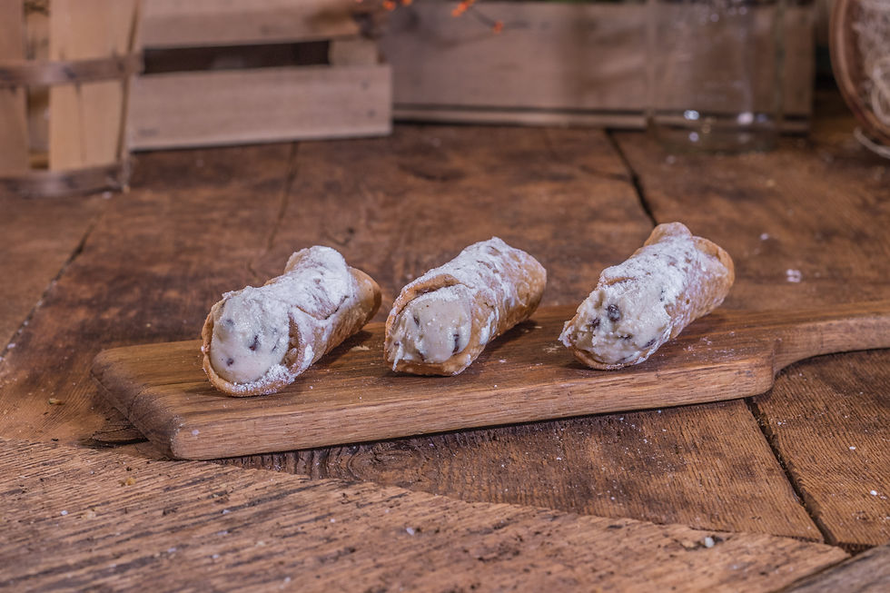 Thumbnail: Three cannoli pastries with powdered sugar on a wooden serving board.
