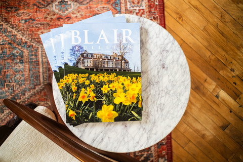 Magazines reading Blair with building and daffodil scene on white table