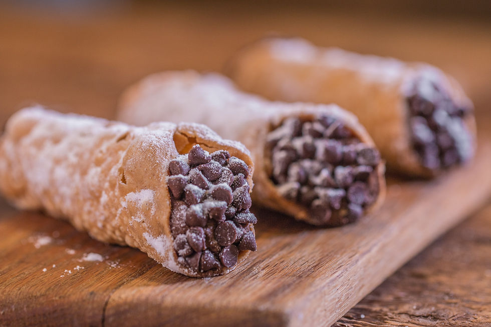 Close-up image of delicious cannolis on a wooden cutting board, ready to eat.