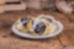 Three pastries with blueberry filling on a white plate