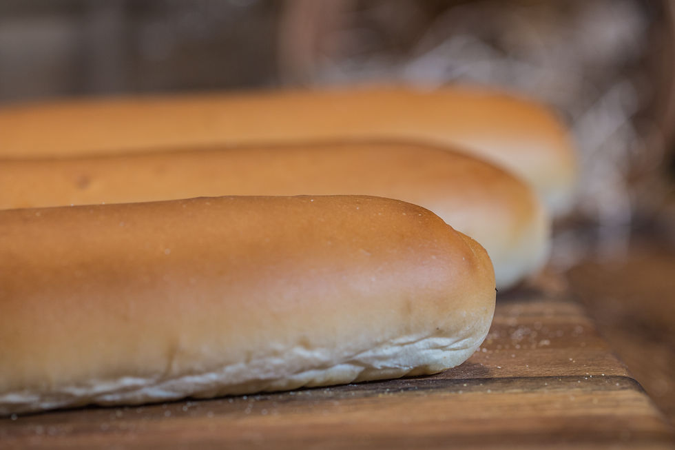 Thumbnail: Three fresh, golden-brown hot dog buns on a wooden surface, ready to serve.