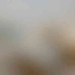 Bedroom with small window, and large bed with a plaid bedspread.