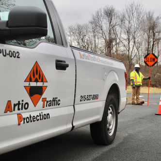 Artio Traffic truck with a worker and a slow sign. Artio Traffic Protection.